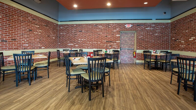 Dining room with many set tables and brick walls
