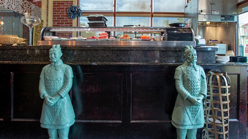 Asian statues in front of sushi bar